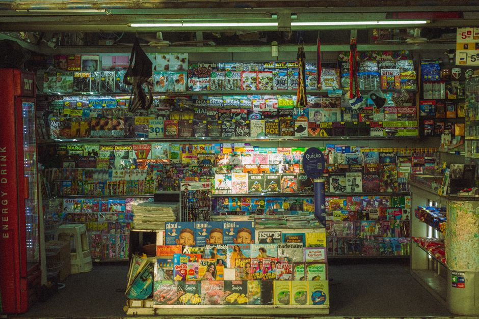 Colorful magazine stand filled with diverse publications in an urban environment.